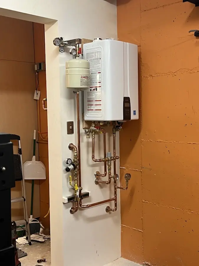 Plumbing technician inspecting water heater connections in Woodbury Heights